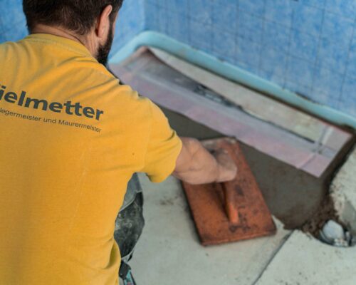 Vielmetter, Meisterbetrieb für Fließen und Maurerarbeiten, saniert gerade den Boden einer Dusche in einem Badezimmer